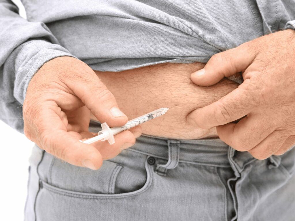 a man administering weekly weight loss injection